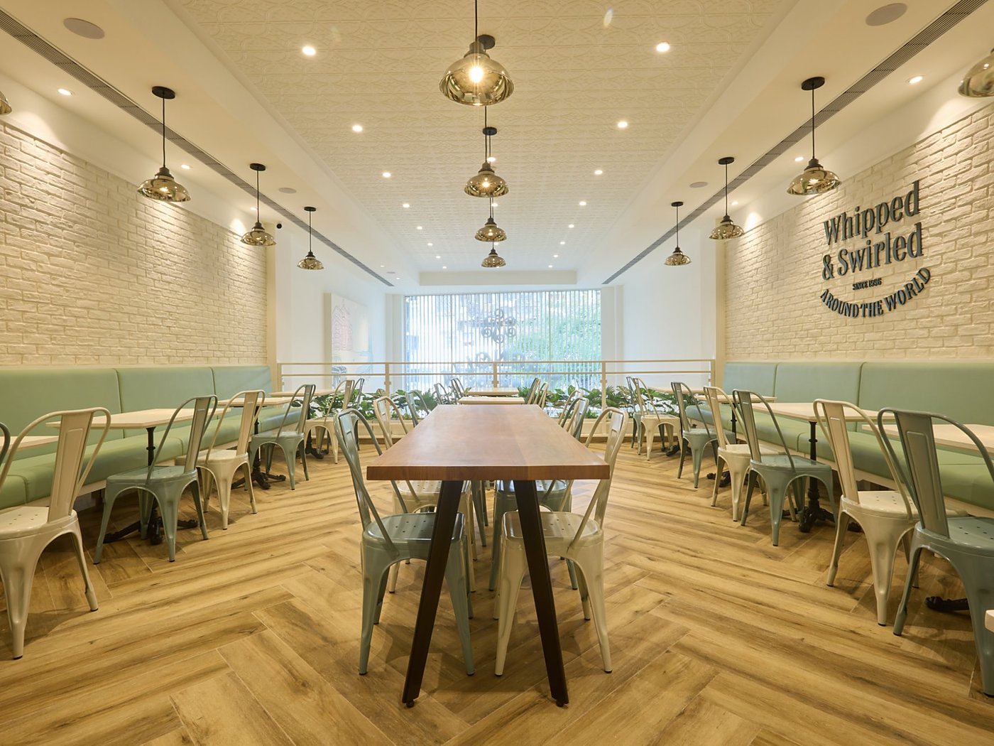 The mezzanine seating area of a Magnolia Bakery store operated by Spago Foods, with banquette seating and a communal table